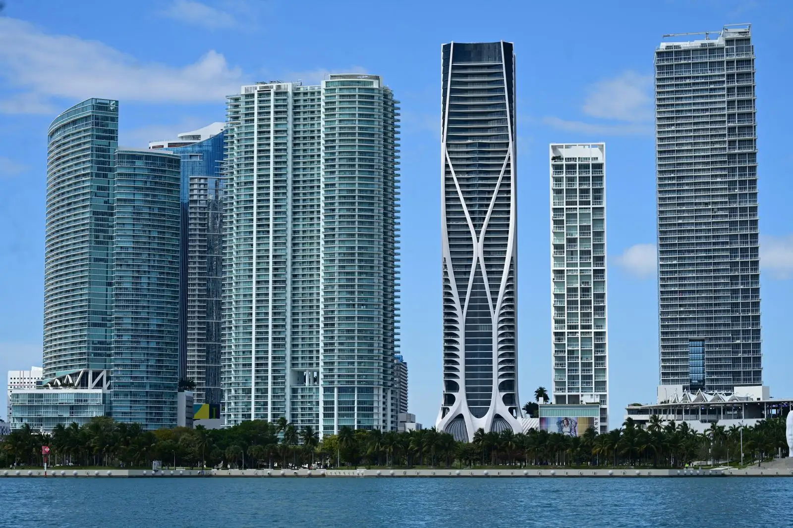 Modern condo towers along the Miami waterfront under a blue sky