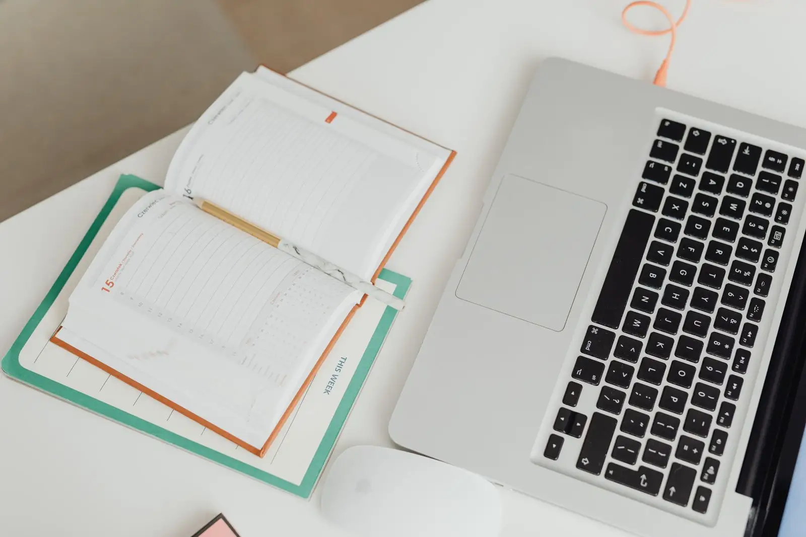 An open planner beside a laptop — planning nightly Airbnb pricing